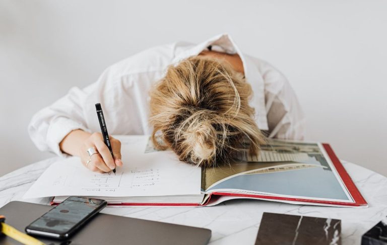 une femme  fatiguée, la tête posée sur le bureau