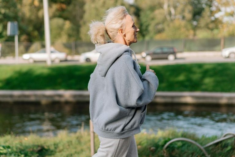 Une femme aux chveux blancs qui court en tenue de sport