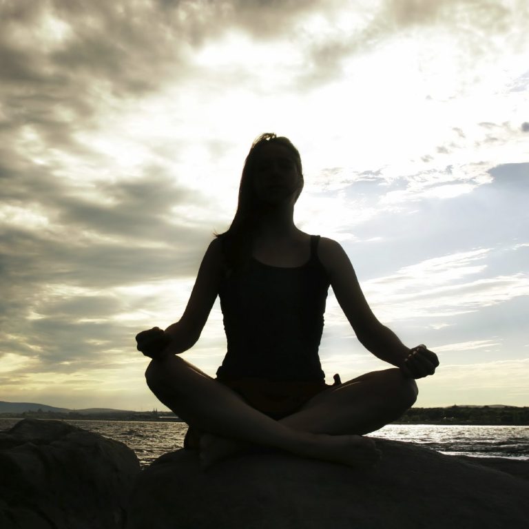 Un femme en contrejour dans la posture du lotus